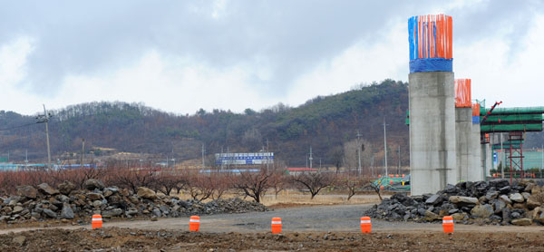 상주-영천 민자고속도로 공사현장 9공구, 매산마을의 과실수 옆에 교량이 건설되고 있다.