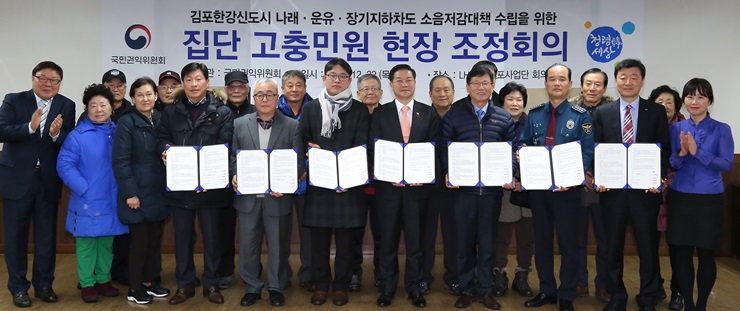 국민권익위원회 성영훈 위원장(가운데)이 22일 오후 경기 김포시 한국토지주택공사 김포사업단에서 '김포한강신도시 내 나래.장기.운유지하차도 소음저감대책 수립을 위한 집단 고충민원 현장조정회의'를 마친 후 관계자, 민원인 등과 조정서를 들고 기념촬영을 하고 있다.